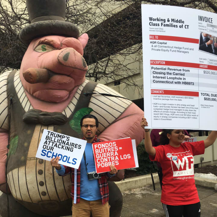 Protesters from the Working Families Organization — and a pig — rally Saturday at the headquarters of AQR Capital in Greenwich. The three co-founders of the hedge fund made last week&#x27;s Forbes list of billionaires.