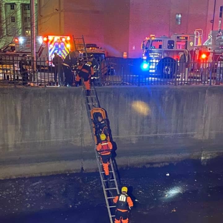 Firefighters rescue a man from the Elizabeth River Sunday evening.