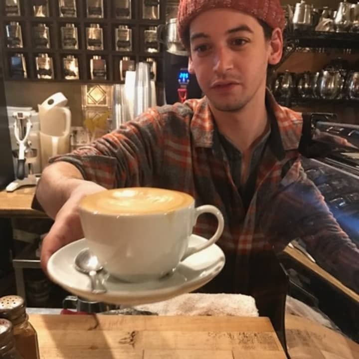 A barista at Art Cafe of Nyack prepares a brimming cup of coffee.