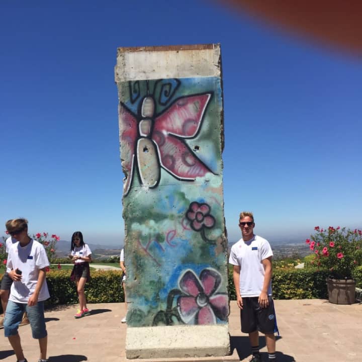 Charles Binder poses with a piece of the Berlin Wall at the Reagan Presidential Library in Simi Valley, California.