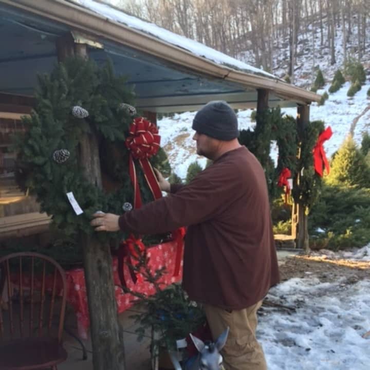 PJ Madsen, an employee at the Cockburn Family Farm in Garrison, adjusts one of the many wreaths that he makes there on recent afternoon.