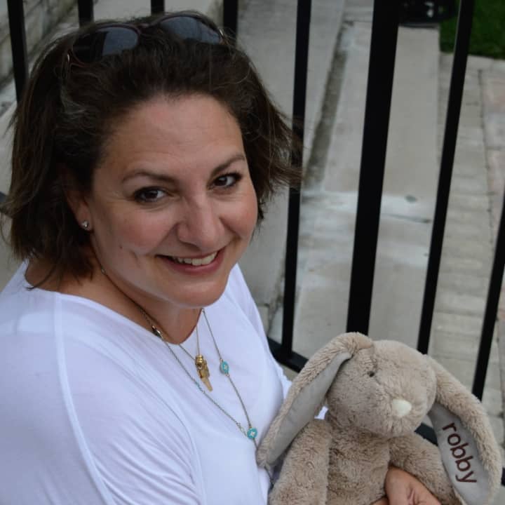 Lisa Oliveri Vreeland holding a stuffed animal from Robby&#x27;s Rabbits on the steps of her church, St. Paul&#x27;s Evangelical Lutheran Church in Closter.