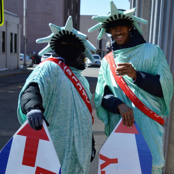 Two men who play the Statue of Liberty changing shifts at a street corner in Hackensack. Alex Bernard is on the right.