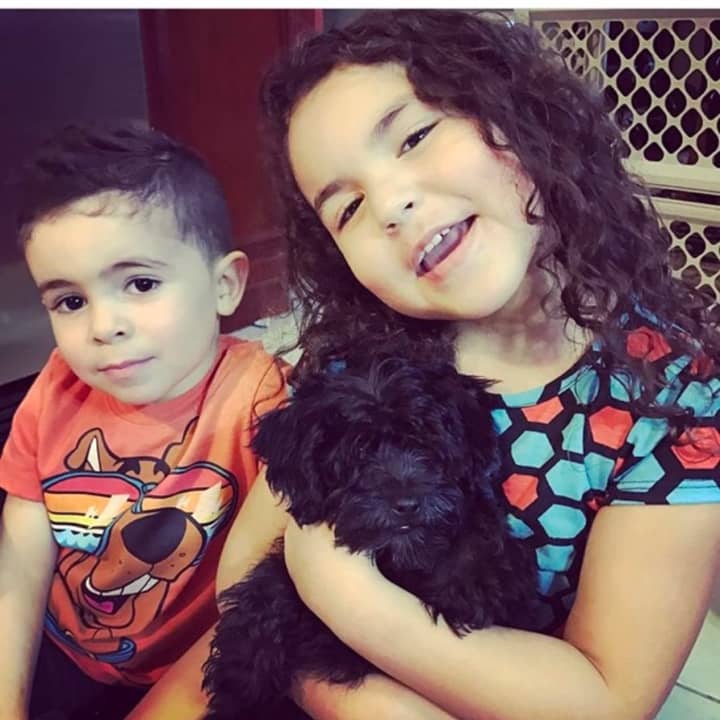 Khloe and Damien Cristostomo with their baby Morkie, who their family rescued after he was surrendered from the Just Pups case.