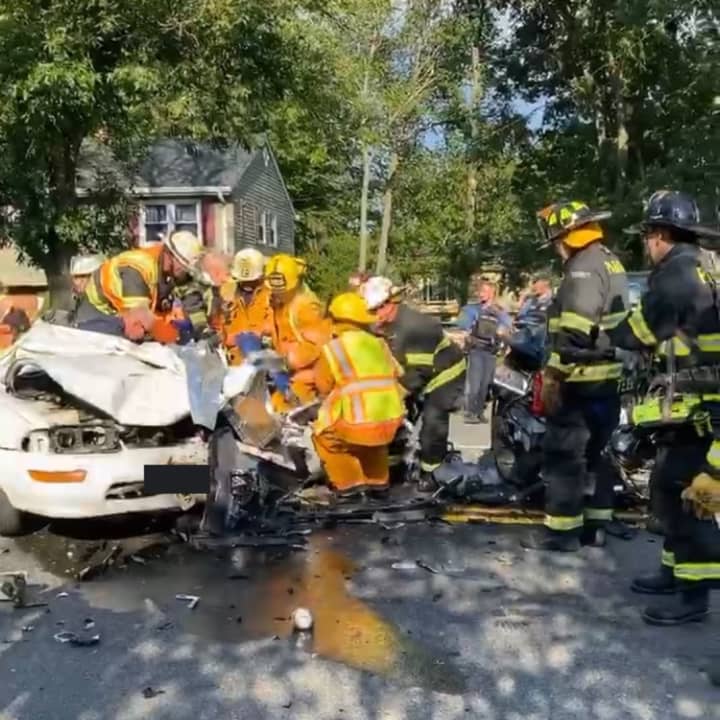 Firefighters cut the roof off of a sedan that collided with a minivan to extricate the driver Monday evening in Paramus.