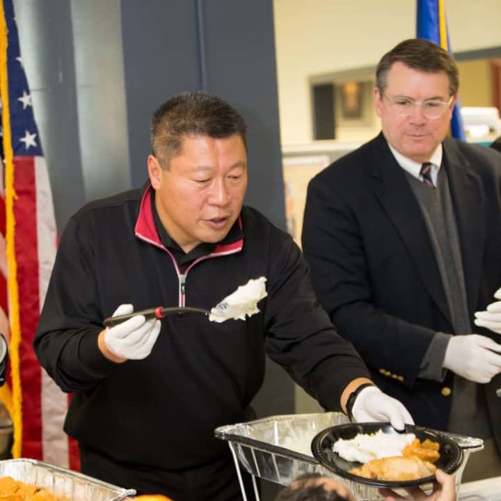 State Sen. Tony Hwang helps serve the annual Thanksgiving dinner at the Bridgeport American Jobs Center.