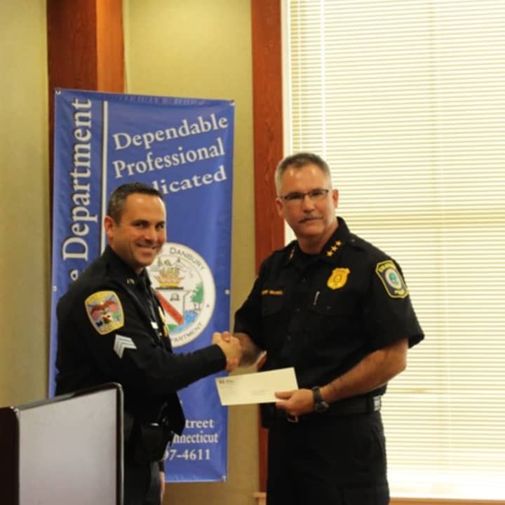 Stratford Police Chief Joseph McNeil accepts his department&#x27;s share of the Gleszer bequest from Danbury Sgt. James Antonelli during a ceremony at Danbury Police Department Wednesday.