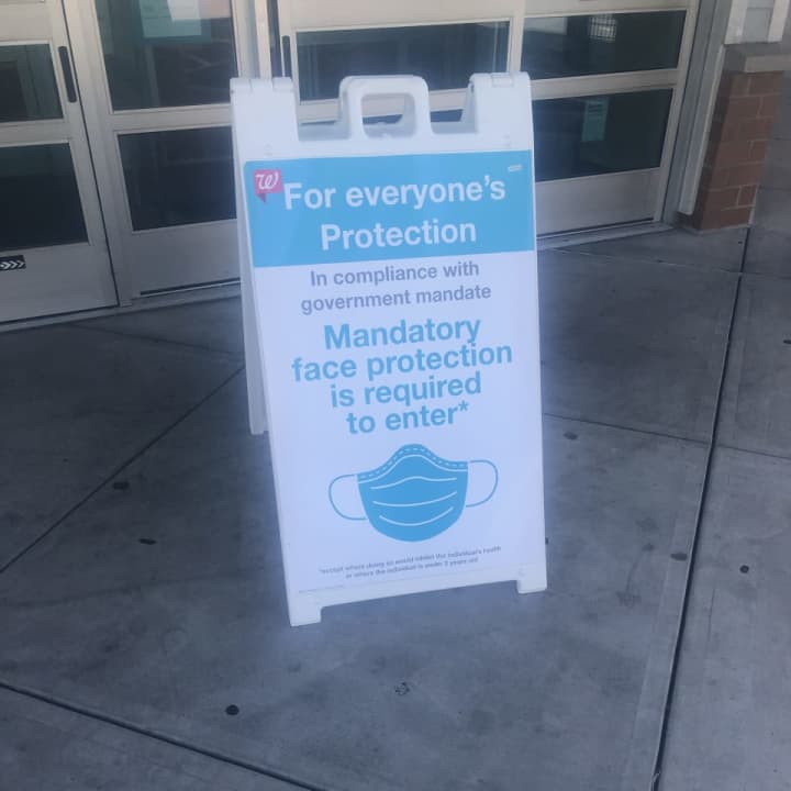Sign outside a Walgreens store stating that customers must wear a mask or face covering.