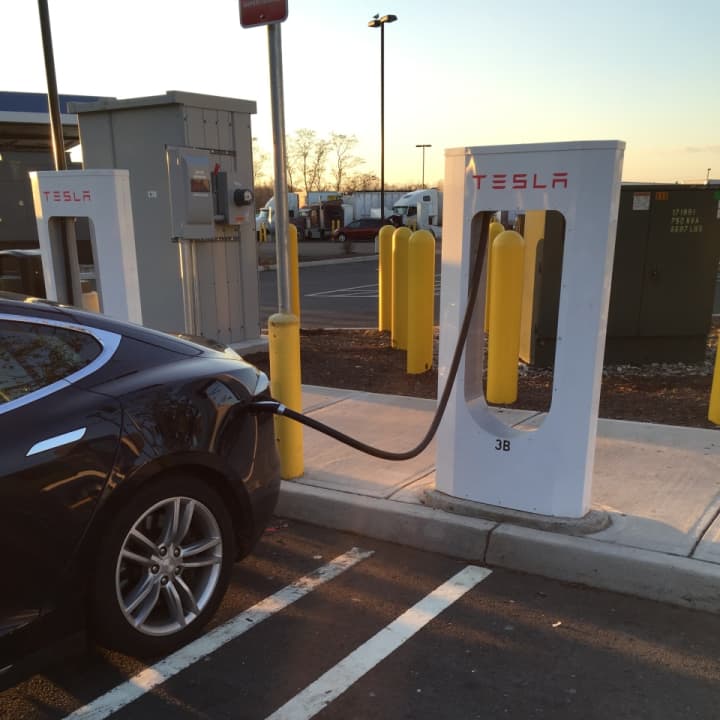 A Tesla recharges at the Darien I-95 South rest area Monday afternoon. The state&#x27;s recently rebuilt service plazas offer charging stations for electric vehicles. 