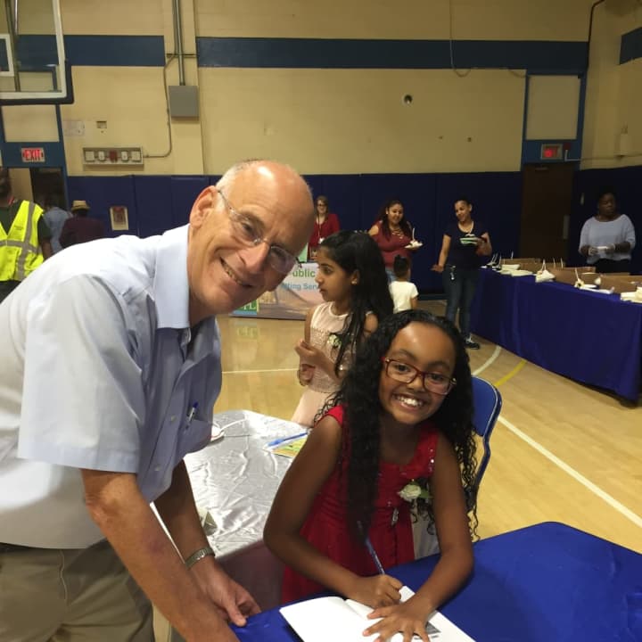 Author Kailani Ledesma , a 4th grader signs her autograph with Paul Feiner.