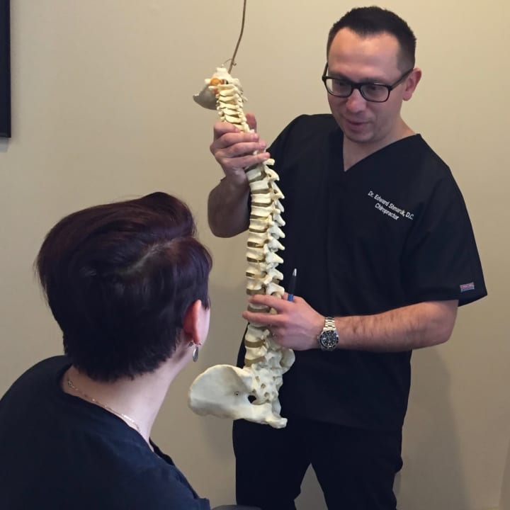 Board certified chiropractor Edward Shmaruk talks with a patient in his Hackensack office.