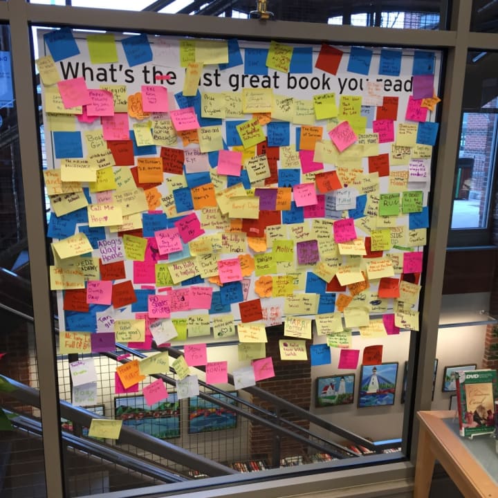 Readers have written the names of their favorite books on sticky notes, which are posted on a window on the Darien Library&#x27;s first floor. 