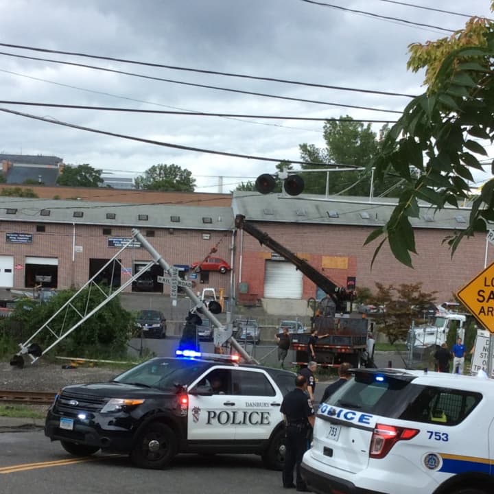 Police on scene of a damaged grade crossing where a car hit a gate in Danbury.