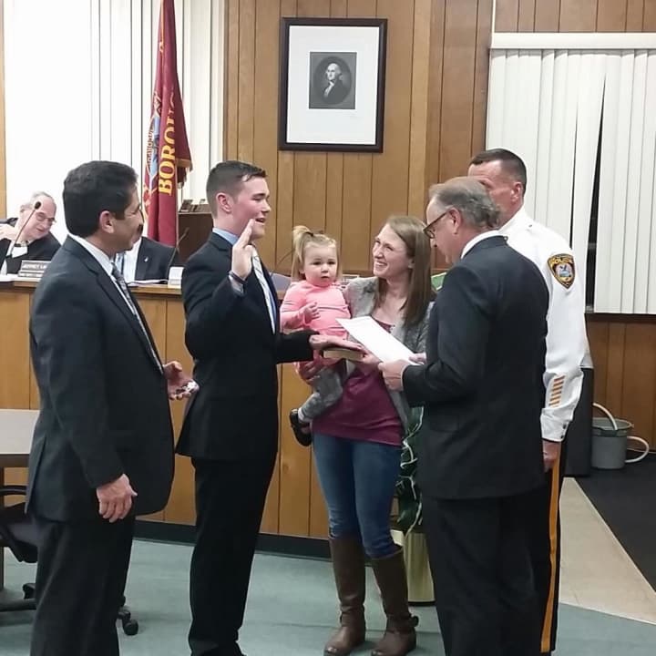 John DeCamp Jr. is sworn in as wife, Rachel, and their daughter, Riley, look on.