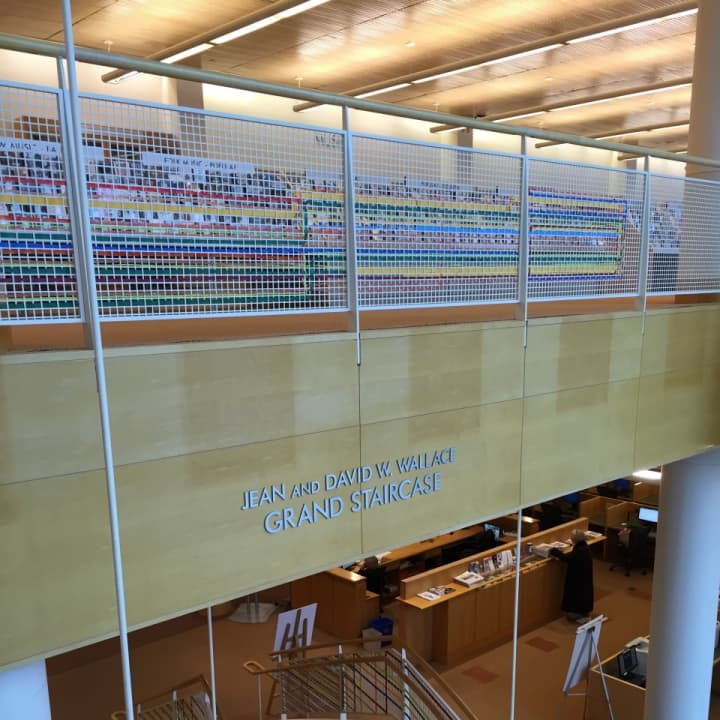 Artist Katherine Daniels created an art installation of colorful plastic strips woven into the gridded surround of Greenwich Library&#x27;s grand stairs.