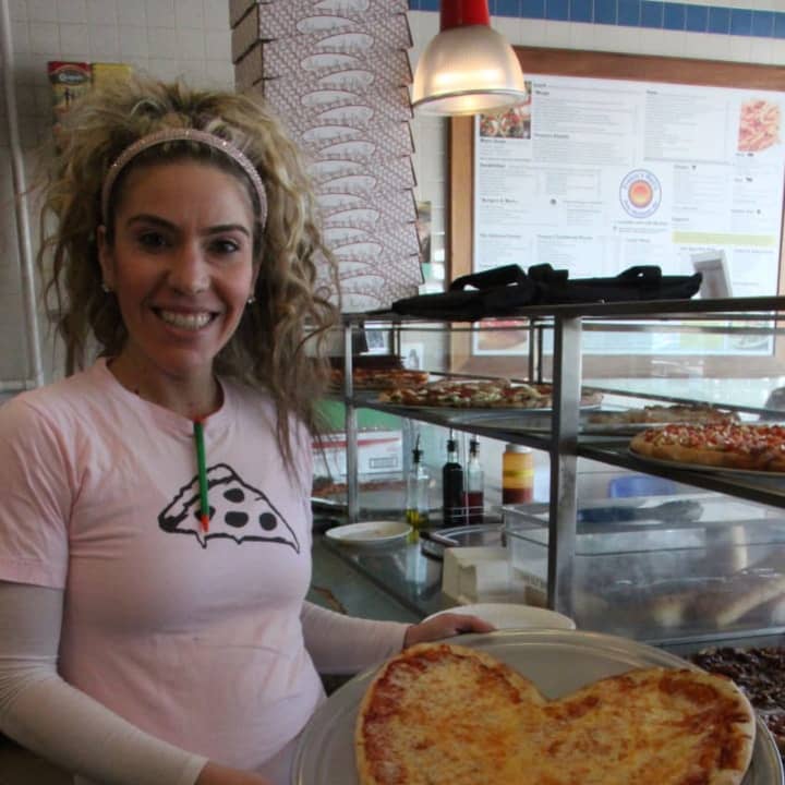 Assistant Manager Melissa Bazzarelli holds up a heart-shaped pizza offered at Franco&#x27;s Metro in Fort Lee, NJ. Only available on Valentine&#x27;s Day.