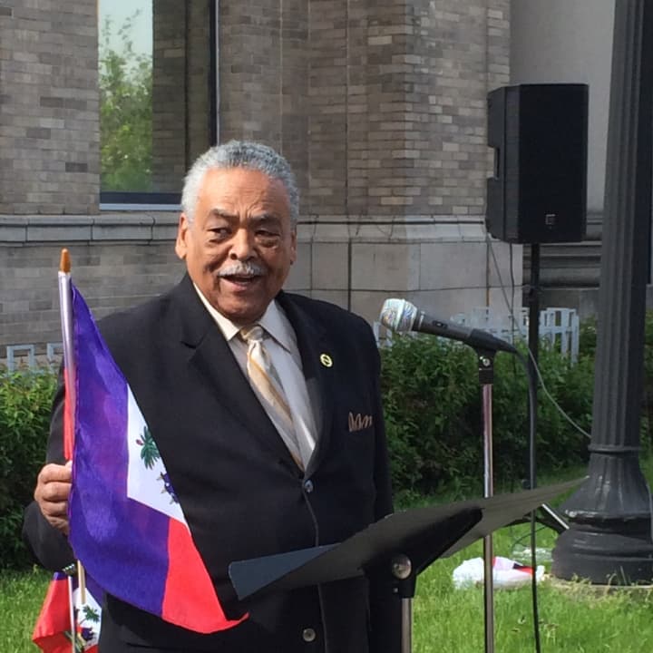 State Sen. Ed Gomes of Bridgeport waves the Haitian flag at a Haitian Flag Day ceremony Wednesday.