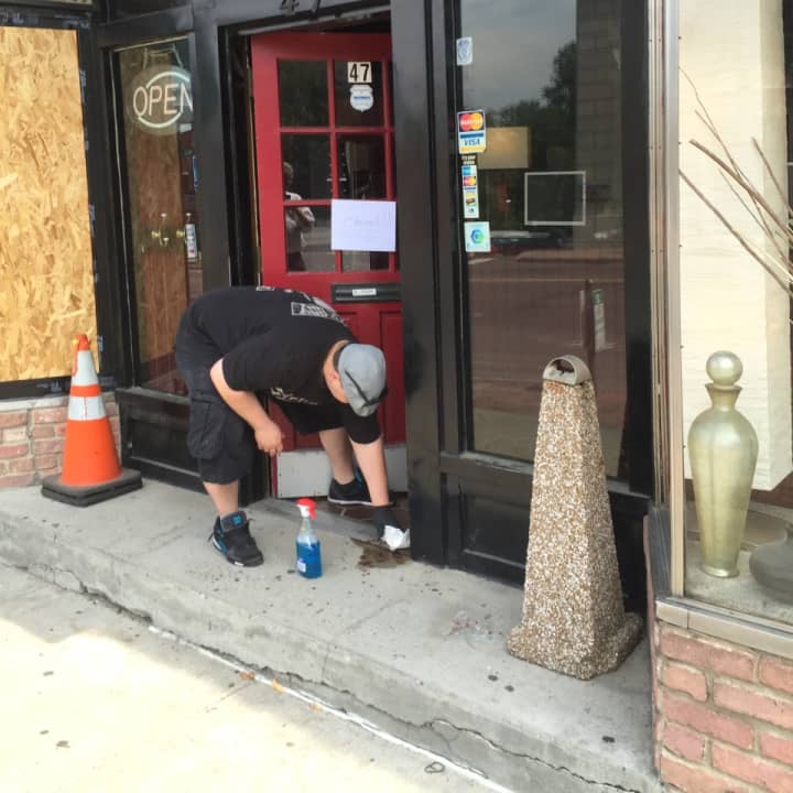 Man cleaning up blood Monday afternoon at the Ink Side Out tattoo shop on Wall Street in Norwalk.