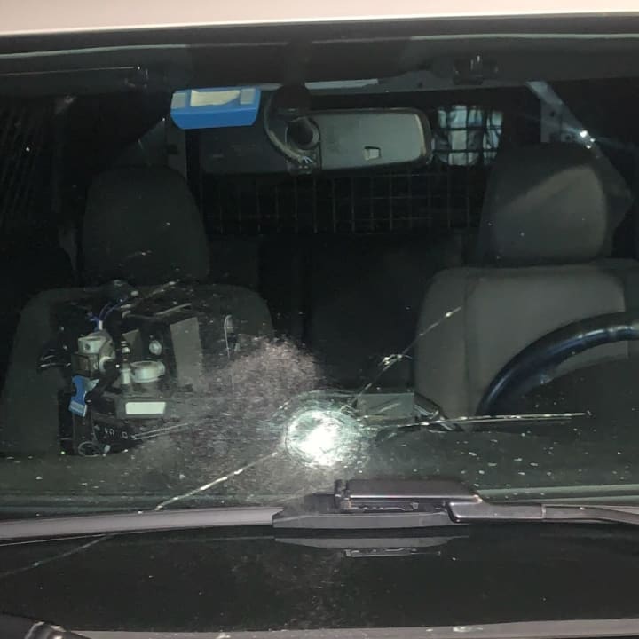 The bullet flew through the windshield of the police cruiser.