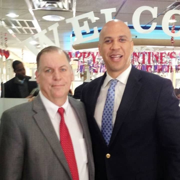 Neighbors Helping Neighbors founder John Fugazzie stands with New Jersey Sen. Cory Booker, in 2014.