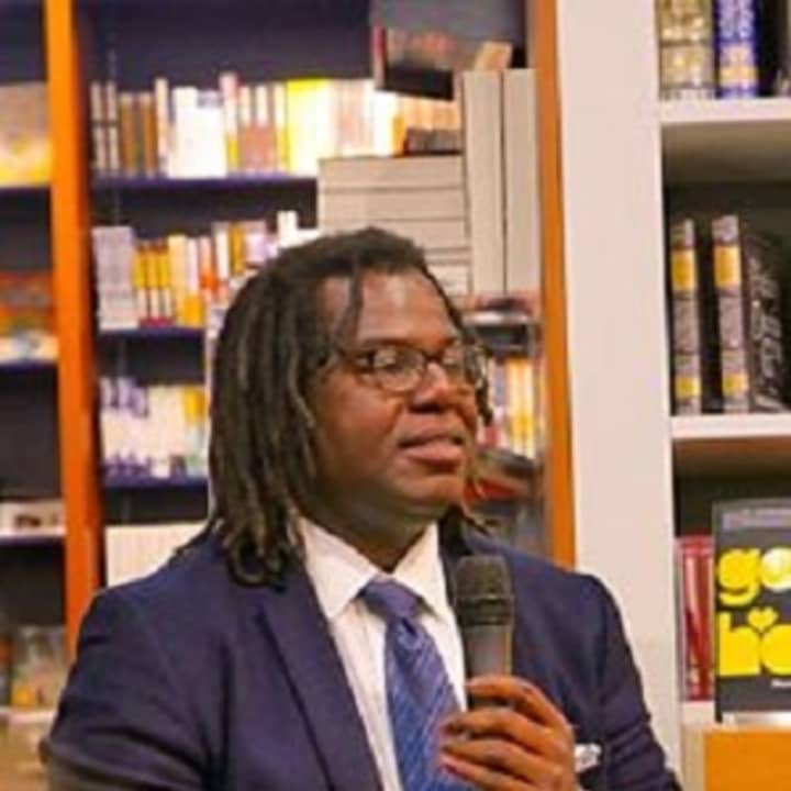 One of two book clubs meeting at the Scarsdale Public Library this month will be discussing Dimitry Léger&#x27;s debut novel, &quot;God Loves Haiti.&quot; Leger is pictured at a book-signing in Zurich.