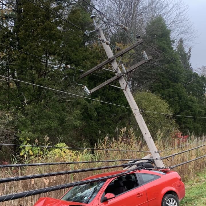 A woman was pinned in her vehicle under live power lines following a crash.