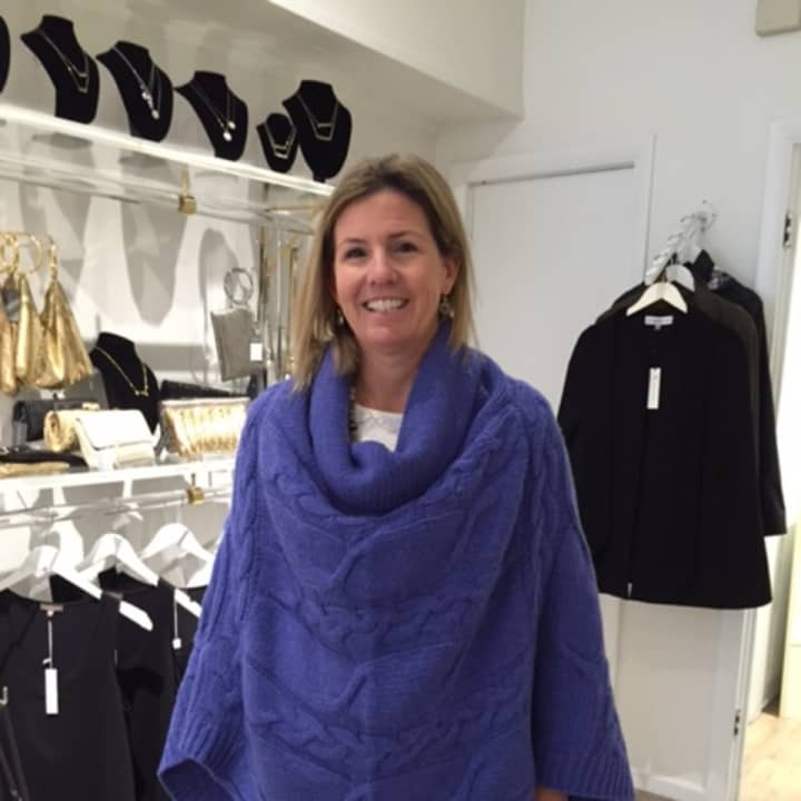 A sales person models a poncho at Palmer &amp; Purchase.