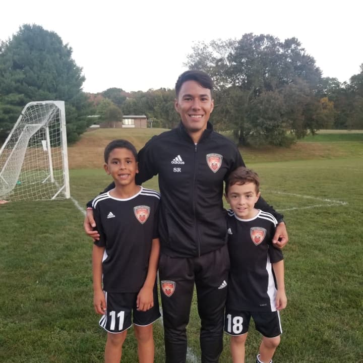 Soccer standouts Kunar, left, and Scalera, right, pose with Coach Rojas.