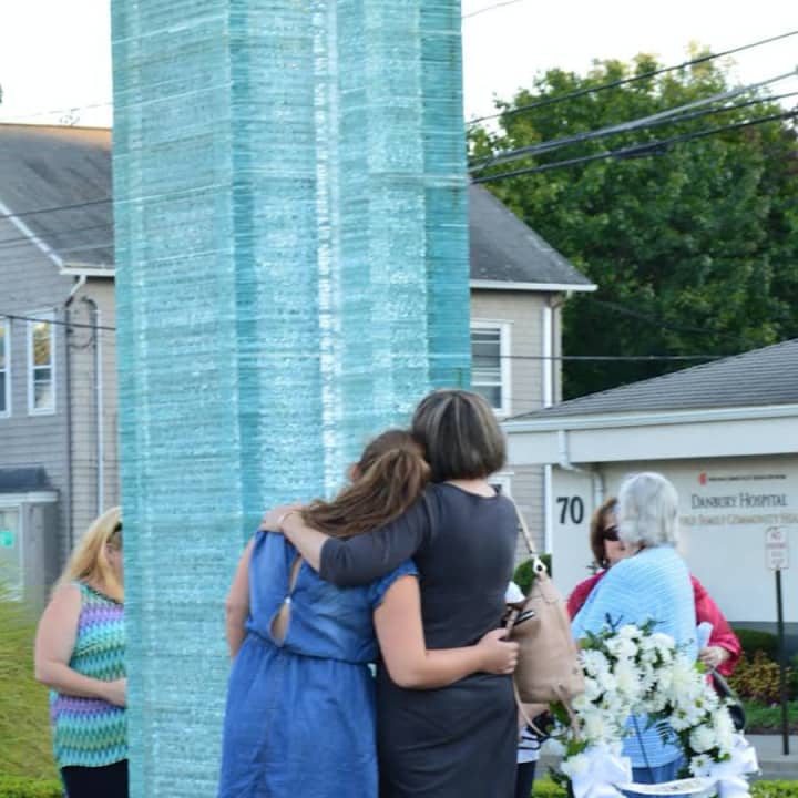 Families hug at the Danbury 9/11 Memorial in Elmwood Park after Friday evening&#x27;s ceremony. 