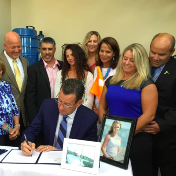 Emily Fedorko&#x27;s parents, Joe and Pam, at right, look on as Gov. Dannel P. Malloy signs Emily&#x27;s Law. Emily, pictured at right, died in a water tubing accident in August 2014 off Greenwich Point. 