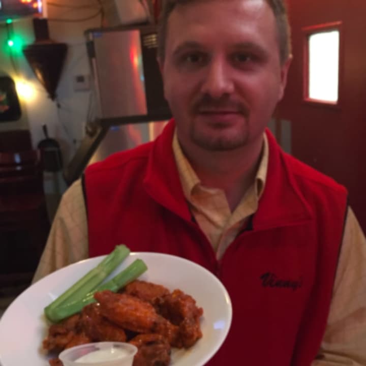 Vinny Backyard&#x27;s General Manager Ben Gashi holding some of the restaurant&#x27;s famous wings.