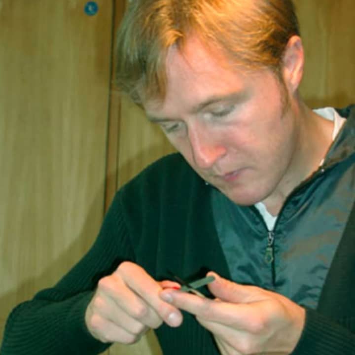 A musician prepares his reed to play the oboe.