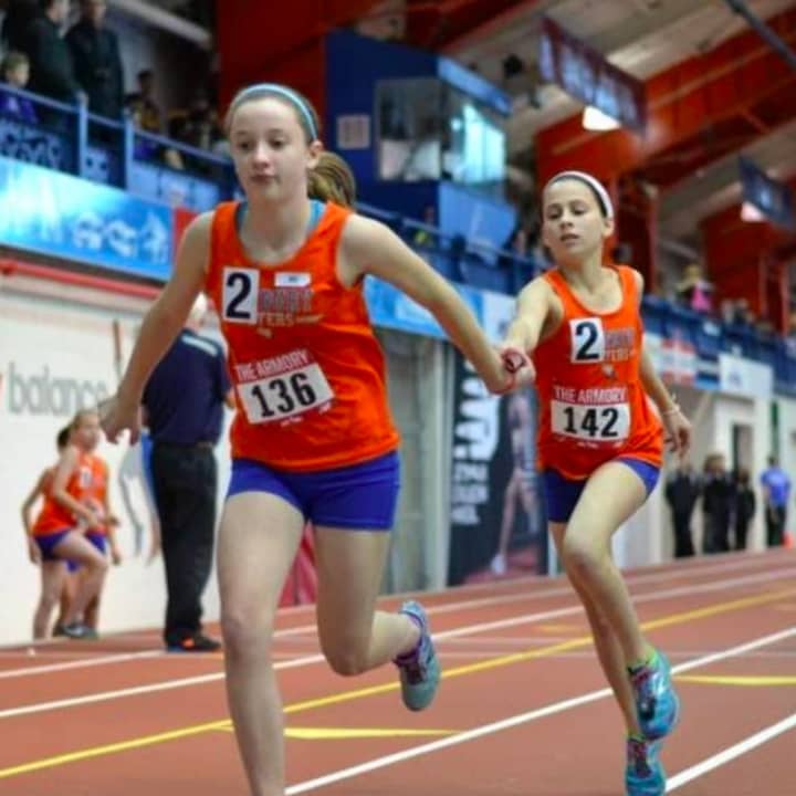 Danbury Flyers girls exchange the baton during a relay race at the meet at the Armory in New York.