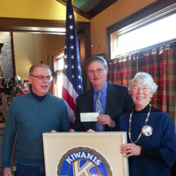 Kiwanis members Tom Maniscalco, left, and Tove Vanderblue, right, present a check to Deputy Chief Chris Lyddy, center.