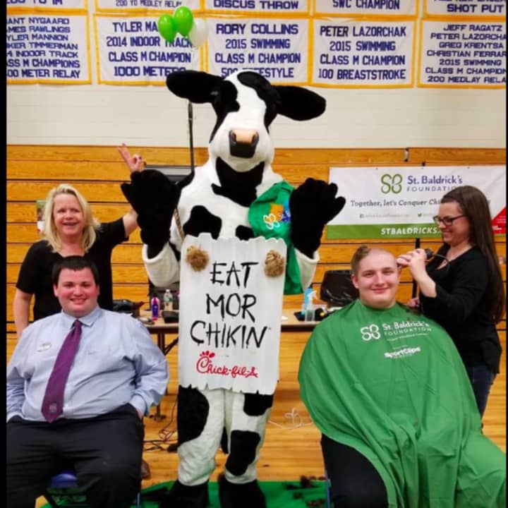 Two team members from Chick-Fil-A shave their heads to show support for childhood cancer research at Brookfield High School&#x27;s Peer Counselor fundraiser.