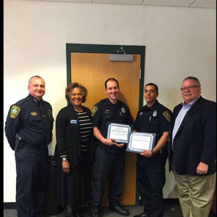 From left, Chief Thomas Kulhawik, Commissioner Fran Collier-Clemmons, Officers Brendan Collins and Daniel Vazquez and Commissioner Charles Yost. Collins and Vazquez were honored for saving the life of a car crash victim.
