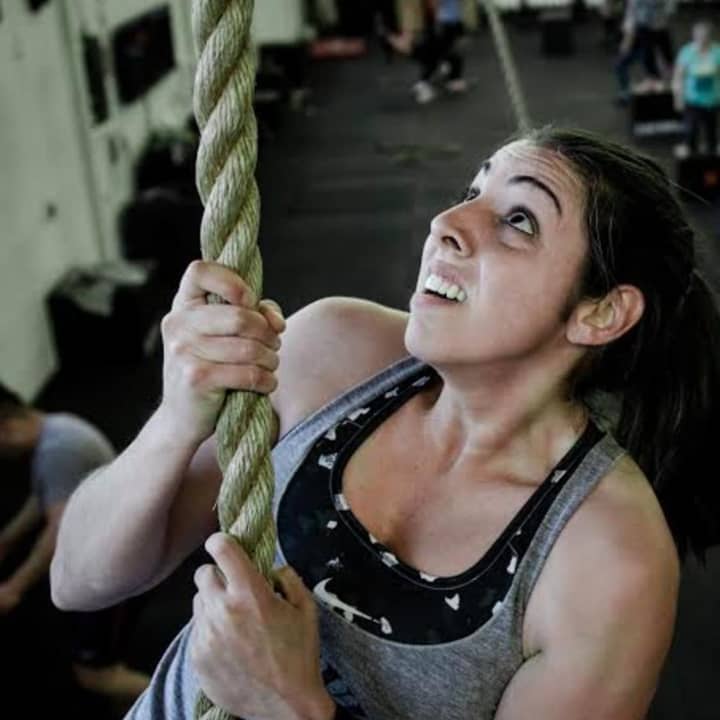 <p>State Trooper Dana Wilcomes climbs a rope in Guerrilla Fitness Paramus.</p>