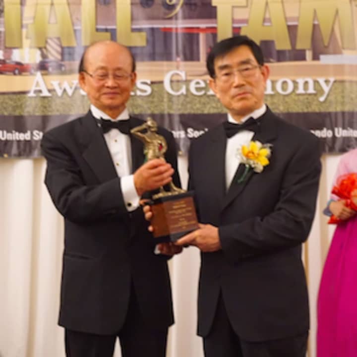 Grand Master Hyun Ok Shim, left, presents the Hall of Fame award to Grand Master Ik Jo Kang.