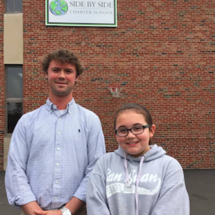 Norwalk Side by Side Charter School fifth grade teacher Chris Berich and fifth grade student Samantha Stone at the Perennial Human Rights Garden ceremony at the school Friday.