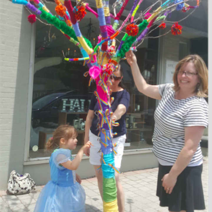 Avery Friedland, left, along with her mother Meghan Friedland and Toy Room owner Kim Ramsey examine the tree that was decorated to honor the victims of the Orlando shooting.