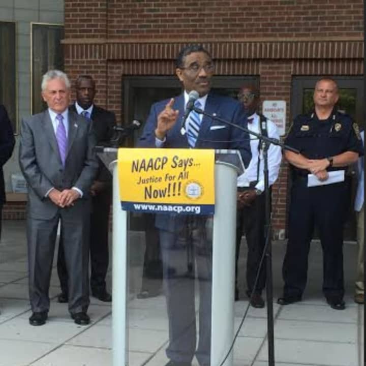 Norwalk State Rep. Bruce Morris speaks at a rally in front of City Hall Tuesday. It was called by the Norwalk NAACP chapter in response to the recent deaths of two black men and five police officers.