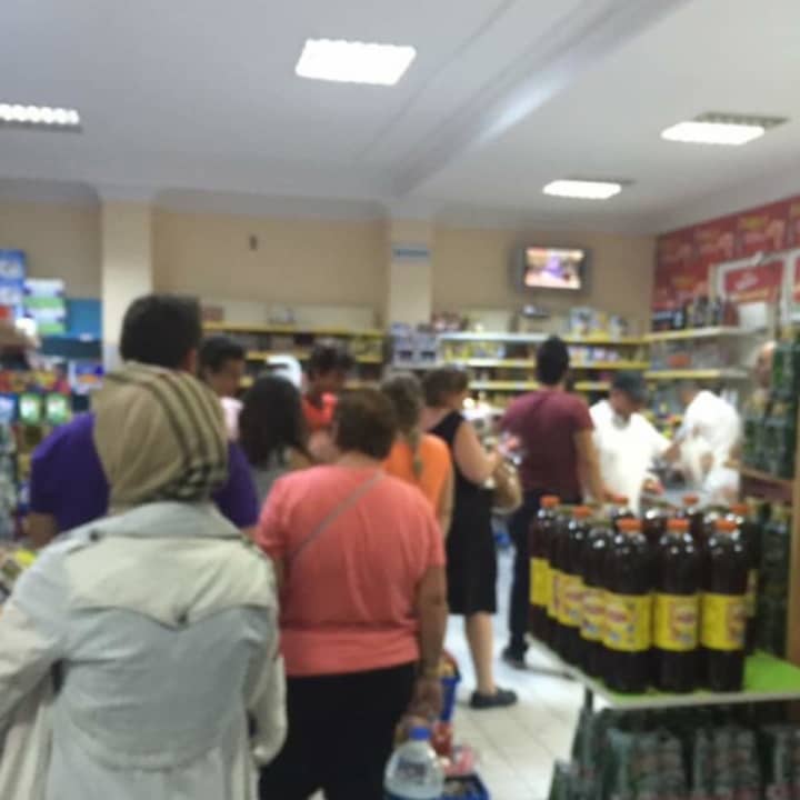 A supermarket crowd gathers to watch reports on the uprising at a supermarket in Turkey.
