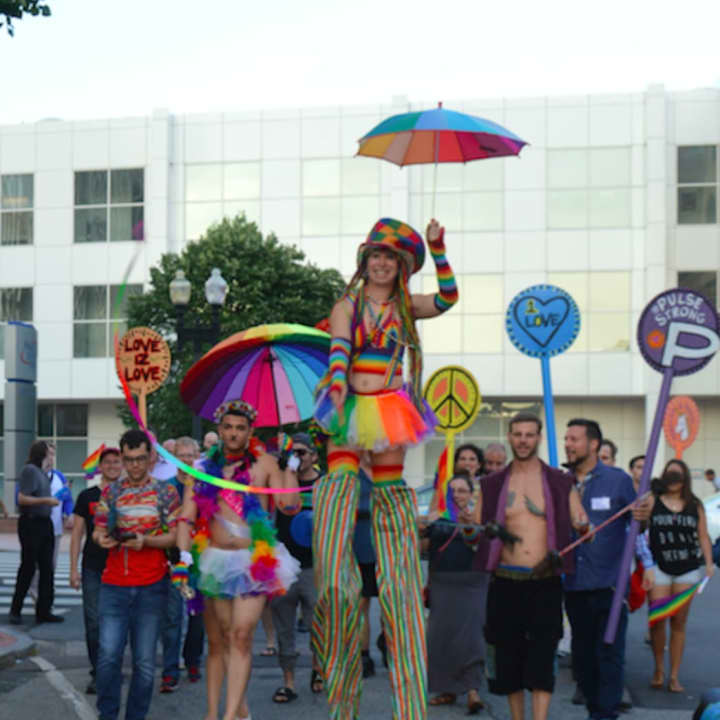 Stilt walker Lady Blaze leads the Pride Walk through downtown Bridgeport at the opening of the SameSex exhibition at City Lights Gallery.