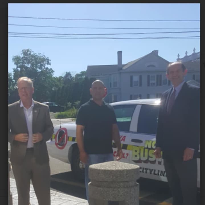 Danbury Mayor Mark Boughton, along with noise control officer Edwin Duran (center) and Les Pinter, deputy corporation counsel, in front of Danbury City Hall with the new Noise Buster cruiser.