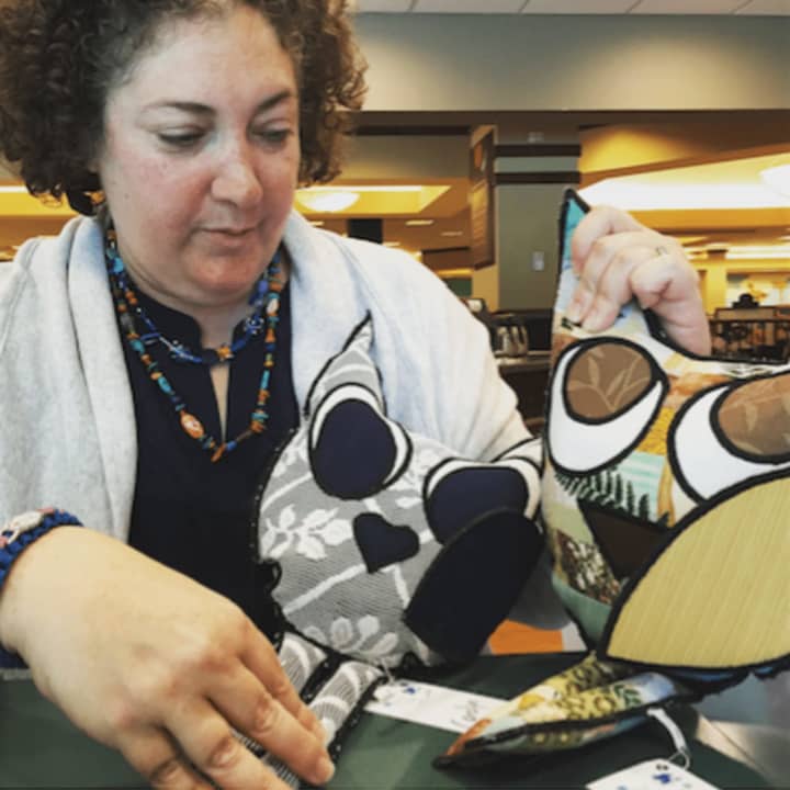 Rutherford&#x27;s Rebecca Weiss displays the owl pillows she packs into Bob&#x27;s Boxes.