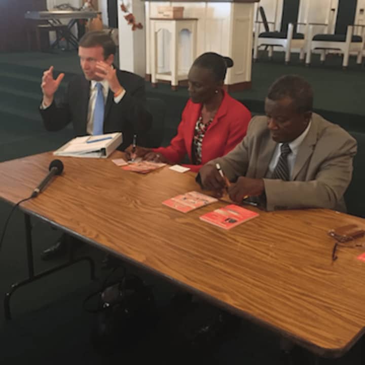 U.S. Sen. Chris Murphy, left, speaking about Haitian relief with members of the Haitian community in a meeting in Bridgeport on Thursday. About 1,000 people have been killed in Haiti due to Hurricane Matthew.