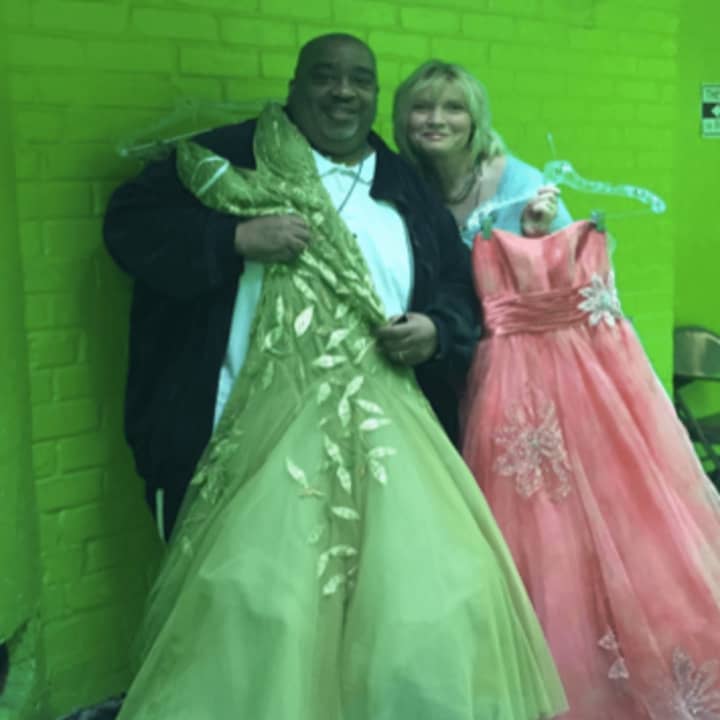 Clyde Thompson and Anne Tack show off some of the donated prom dresses from The Cinderella Project.