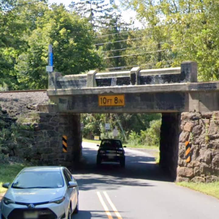 The driver of a box truck was charged Wednesday after the vehicle struck a Hackettstown underpass, overturned and started leaking fluid, authorities said.