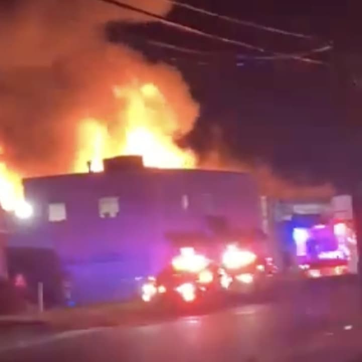 Firefighters from numerous departments are battling a massive seven-alarm fire in a Westbury commercial district.