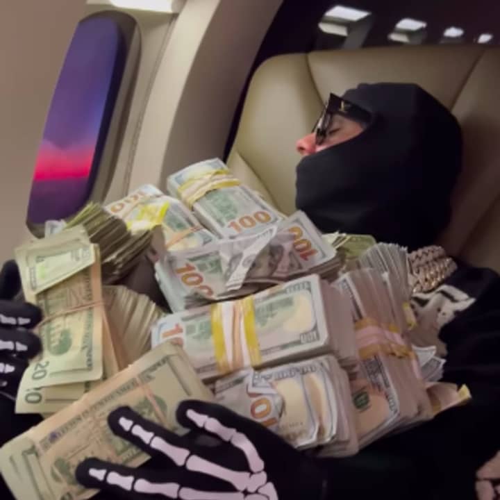 6ix9ine naps with $1 million in cash on his lap.